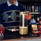 Brass Buster + Punch Takeout LED Portable Lamp on Shop Counter